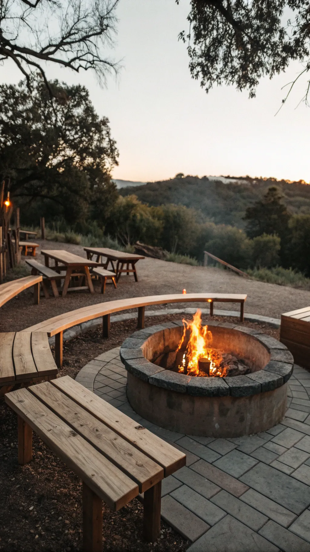 An open flame fire pit with wooden seating benches in a warm outdoor setting.