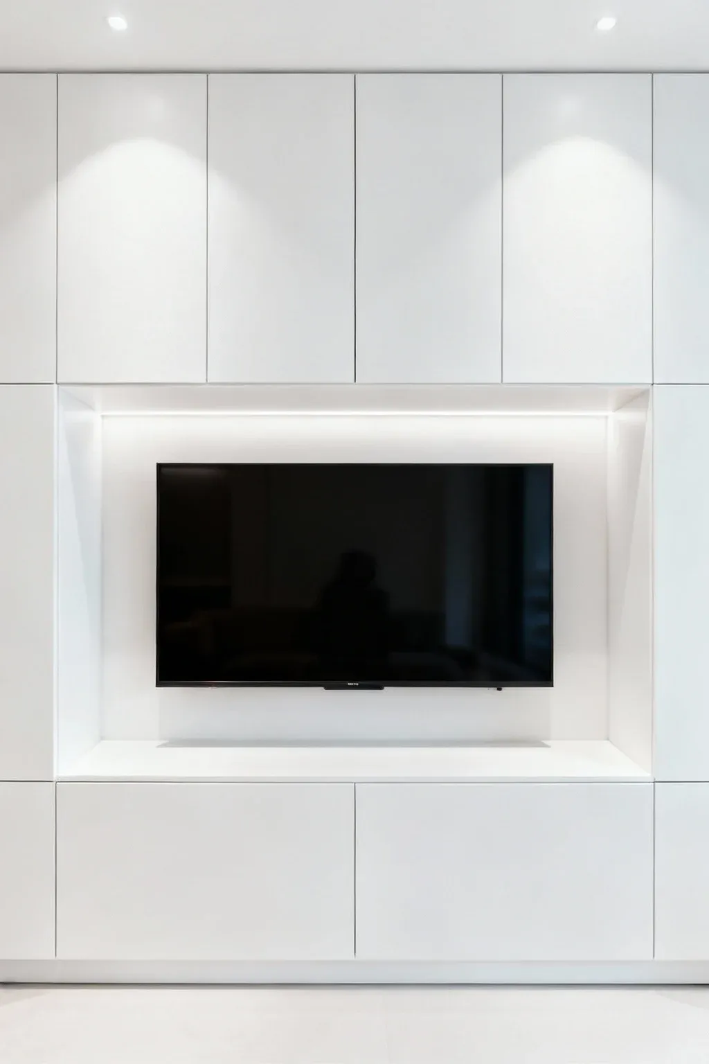 White built-in entertainment unit with closed storage around a TV