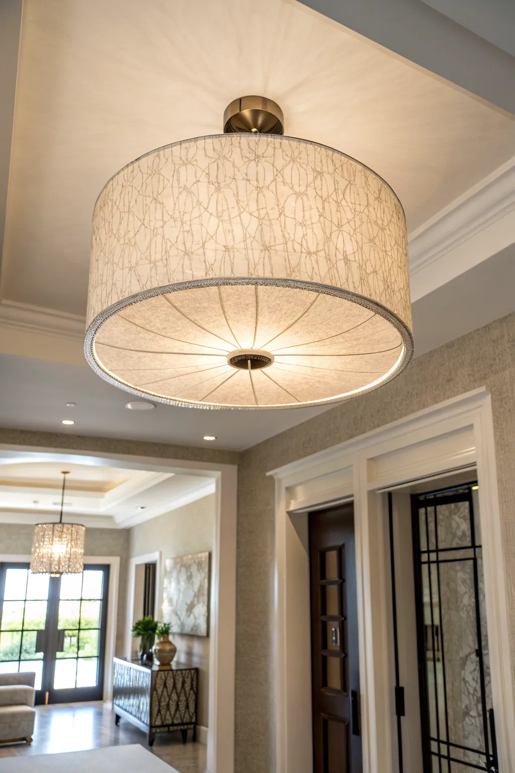 Elegant drum shade ceiling light providing soft glow in an entryway.
