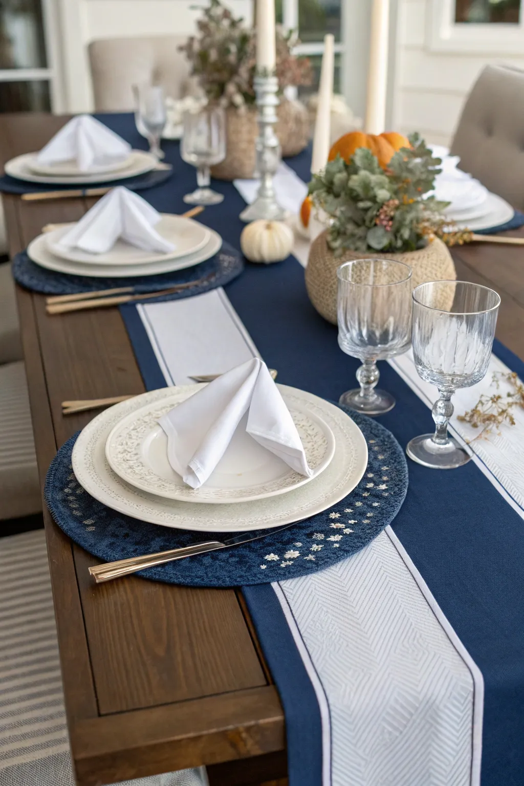Elegant navy table runner with neatly folded white linen napkins tied with twine on a wooden table.