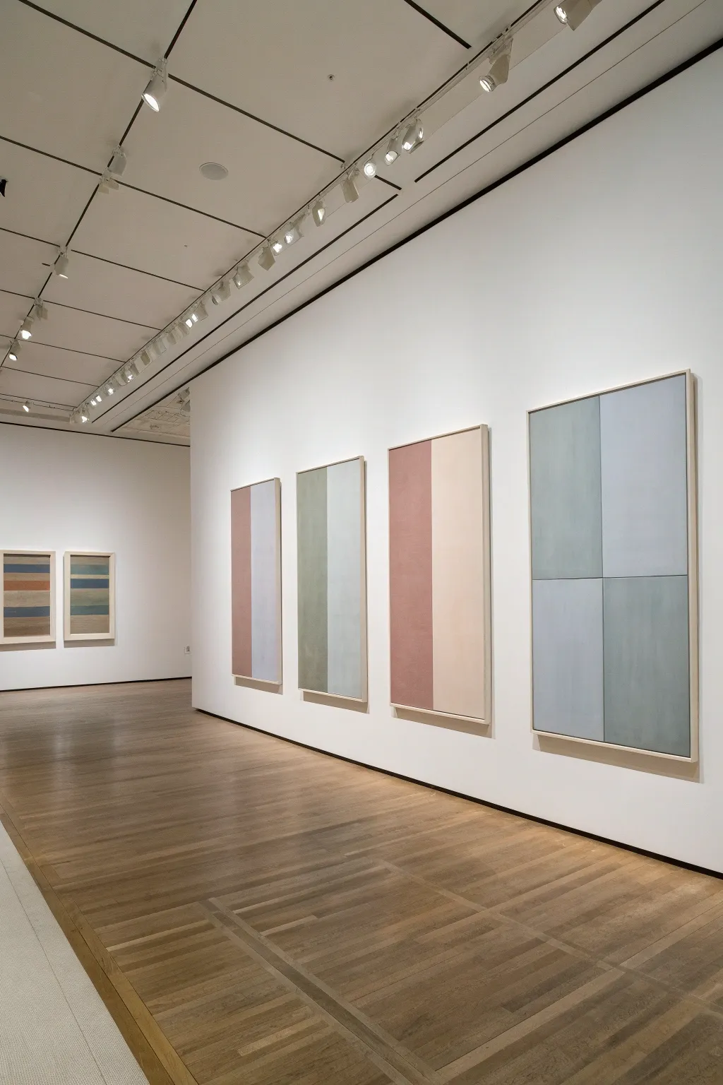 Triptych minimalist wall art with evenly spaced color blocks in soft muted tones on a neutral wall.