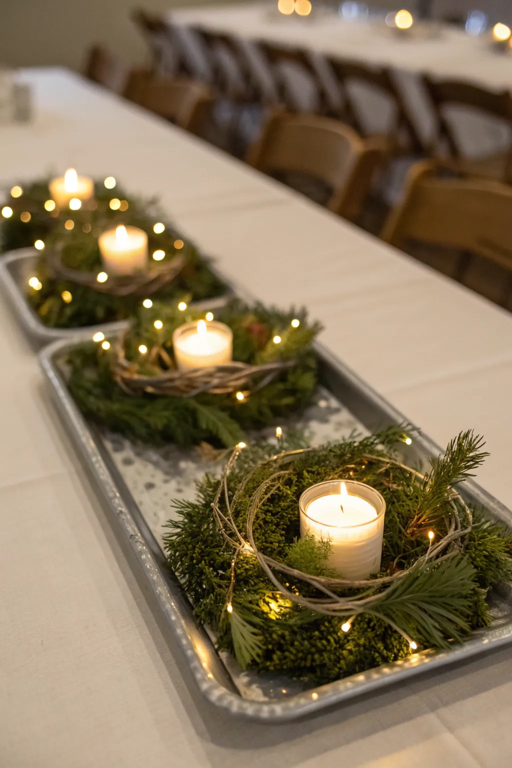 Dining table tray centerpiece with mini wreaths and gently glowing twinkling lights.