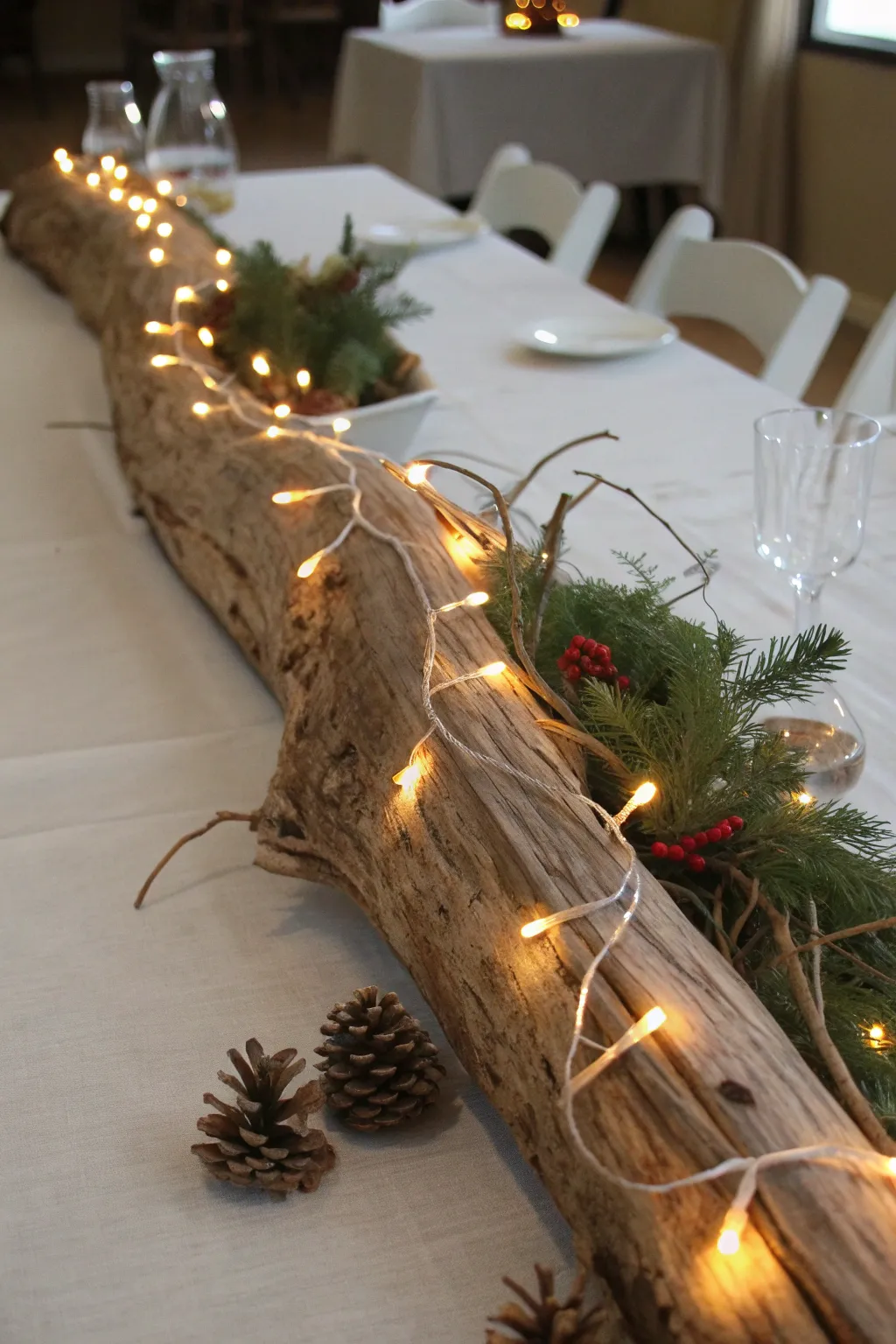 Rustic driftwood wrapped in warm white string lights as a natural Christmas centerpiece.