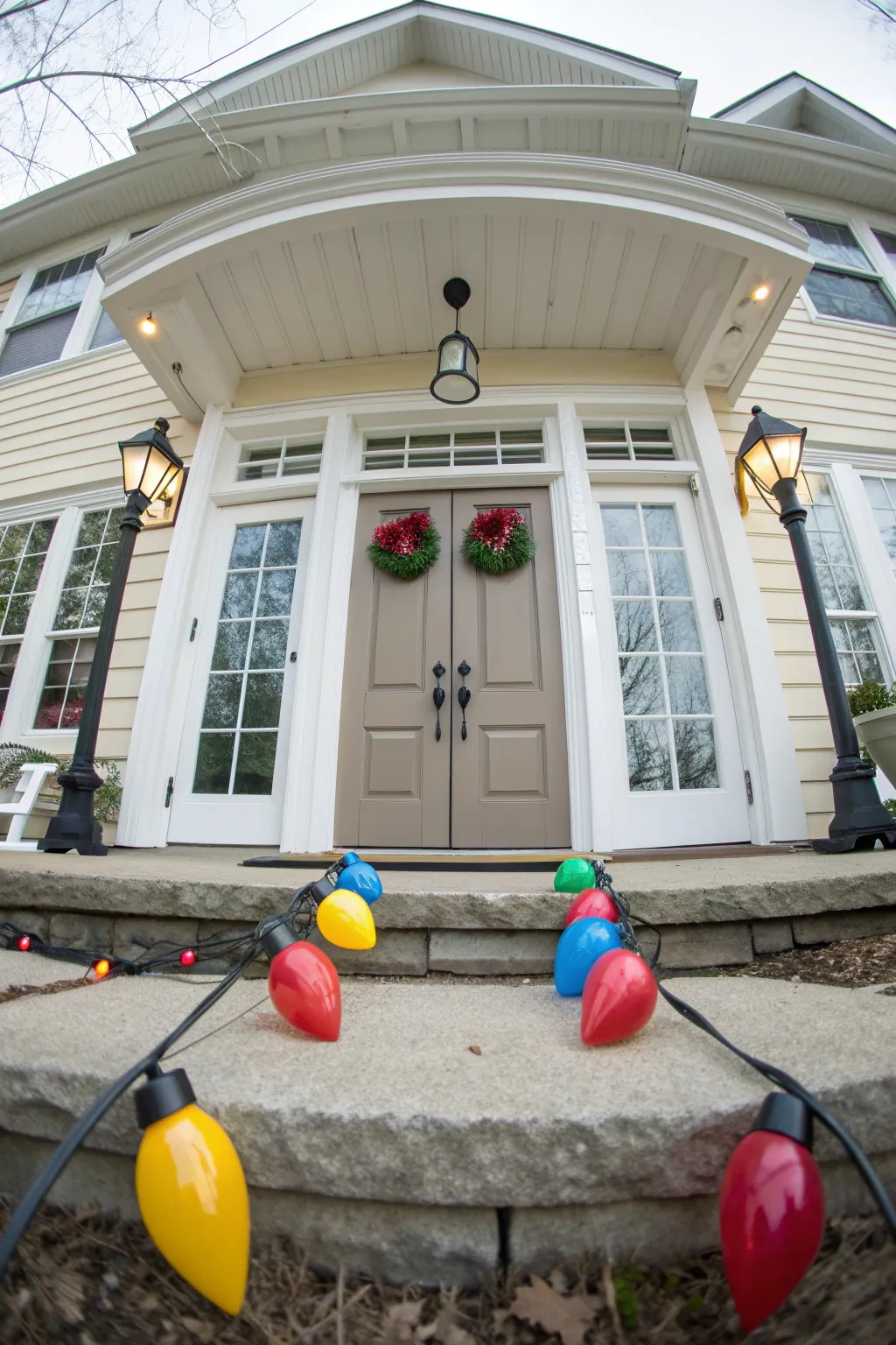 Vibrant multicolored C9 Christmas lights outlining the windows and door of a festive home exterior.