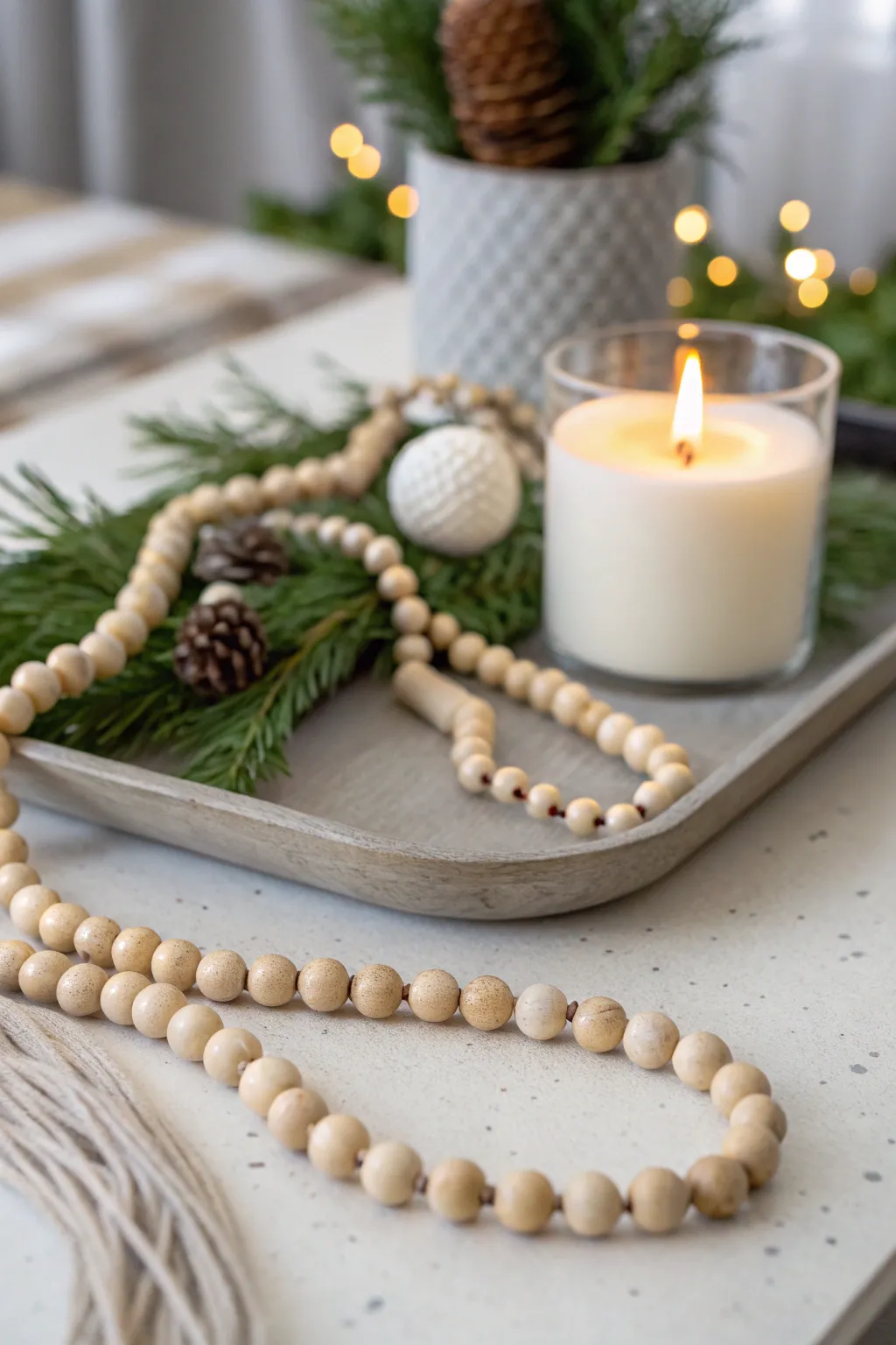 Tray with wooden bead garland draped naturally with greenery or a candle