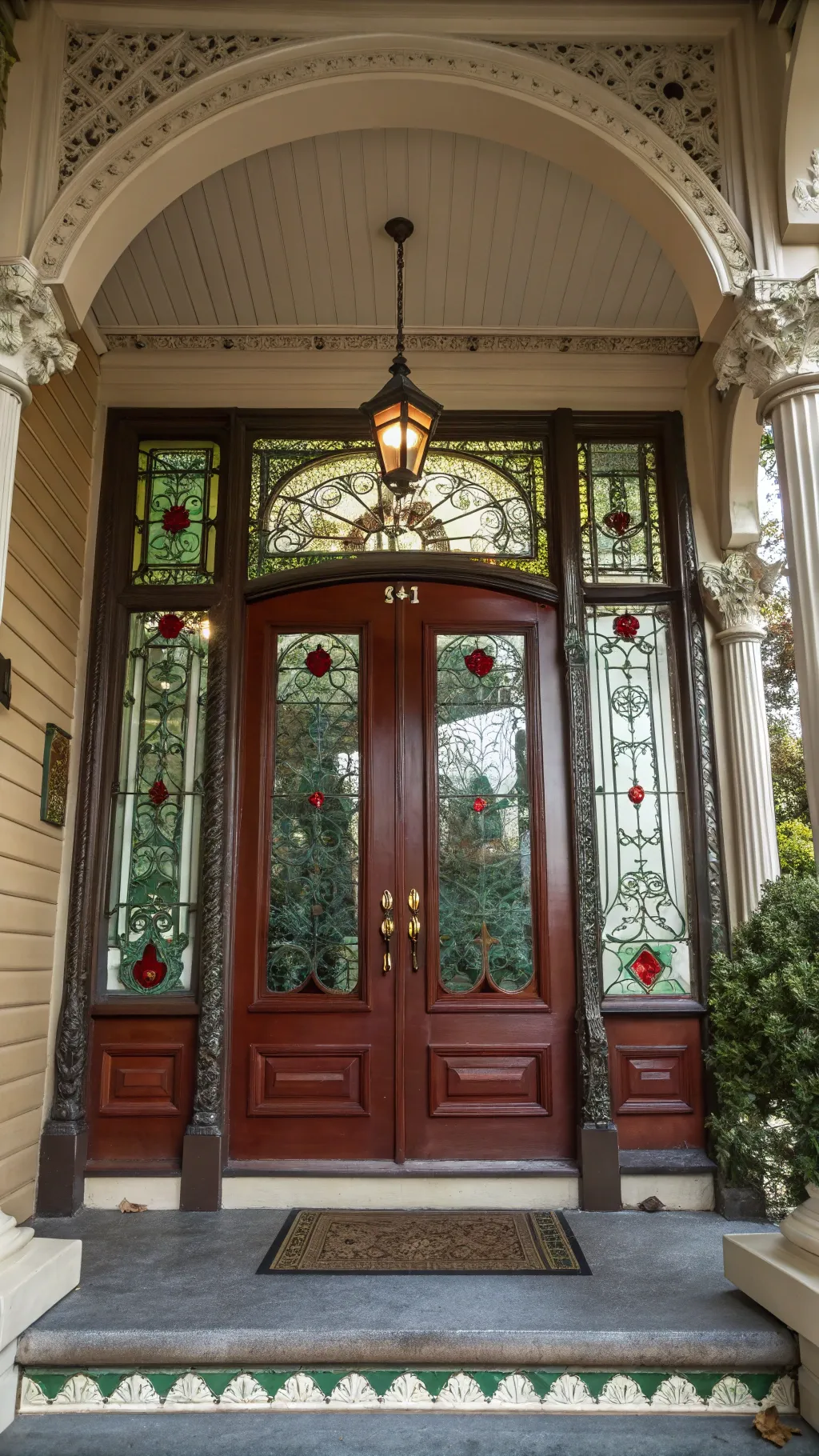 Victorian stained glass panels framing a wood front door with glowing red and green tones.