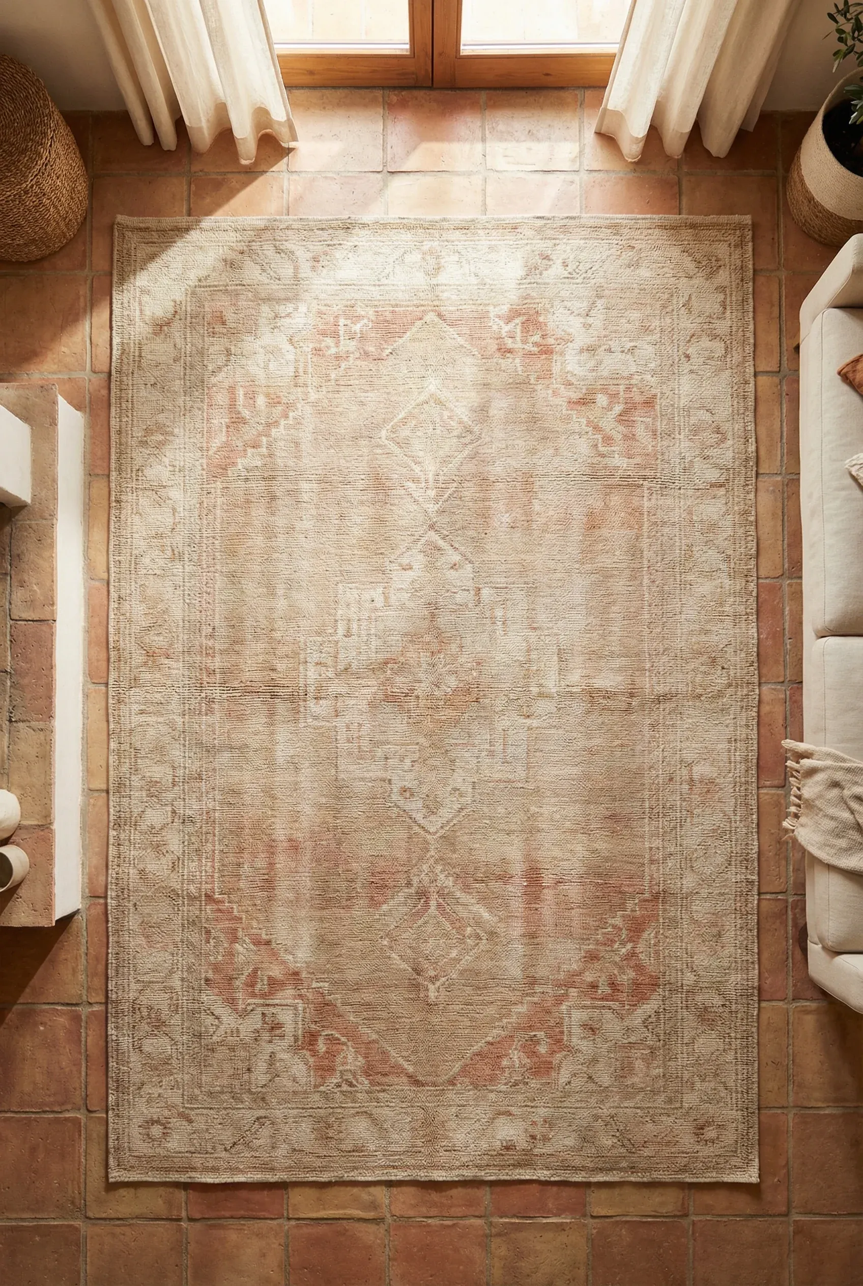 Muted Moroccan-style area rug with soft geometric patterns in a Mediterranean interior.
