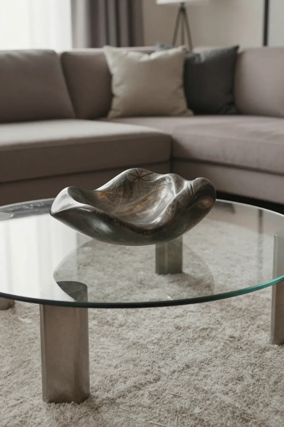 A sculpture as a coffee table centerpiece with a glass top.