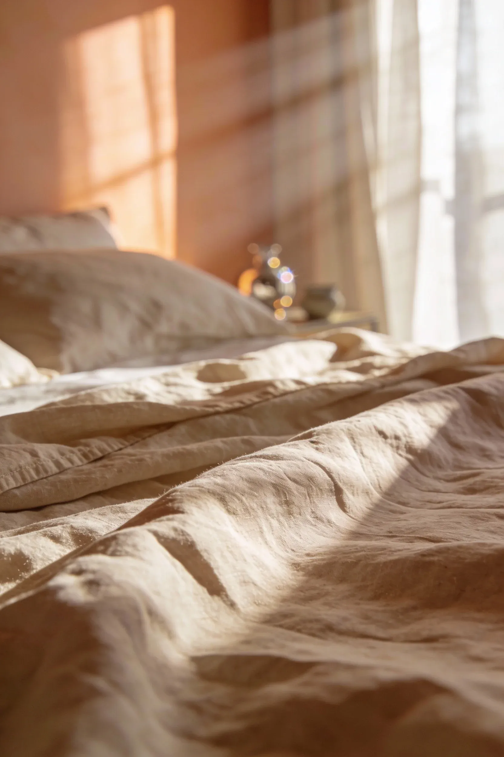 Warm linen bedding in soft neutral shades arranged on a cozy natural-style bed.