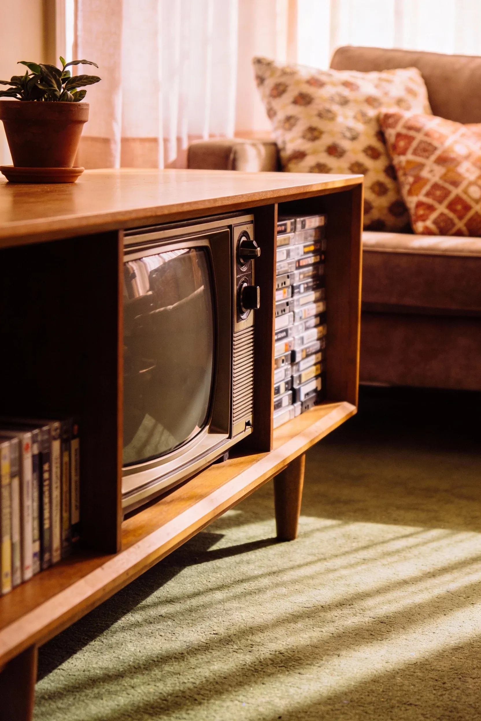 A vintage wooden entertainment console with a CRT TV, evoking 90s nostalgia.