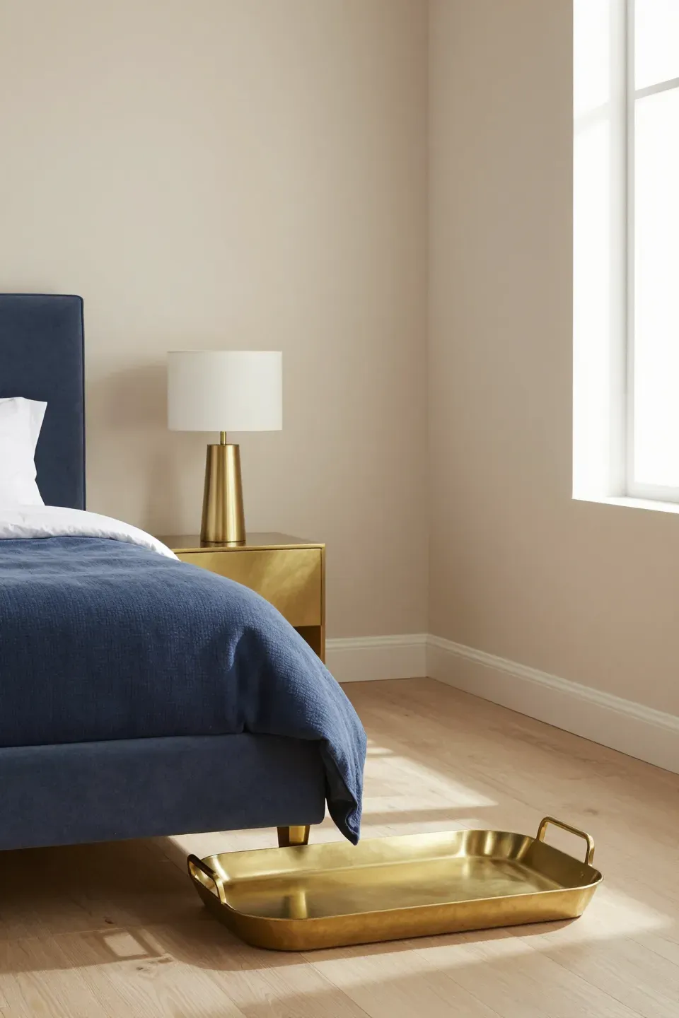 A stylish bedroom with brushed brass decor accents enhancing the blue and beige theme.