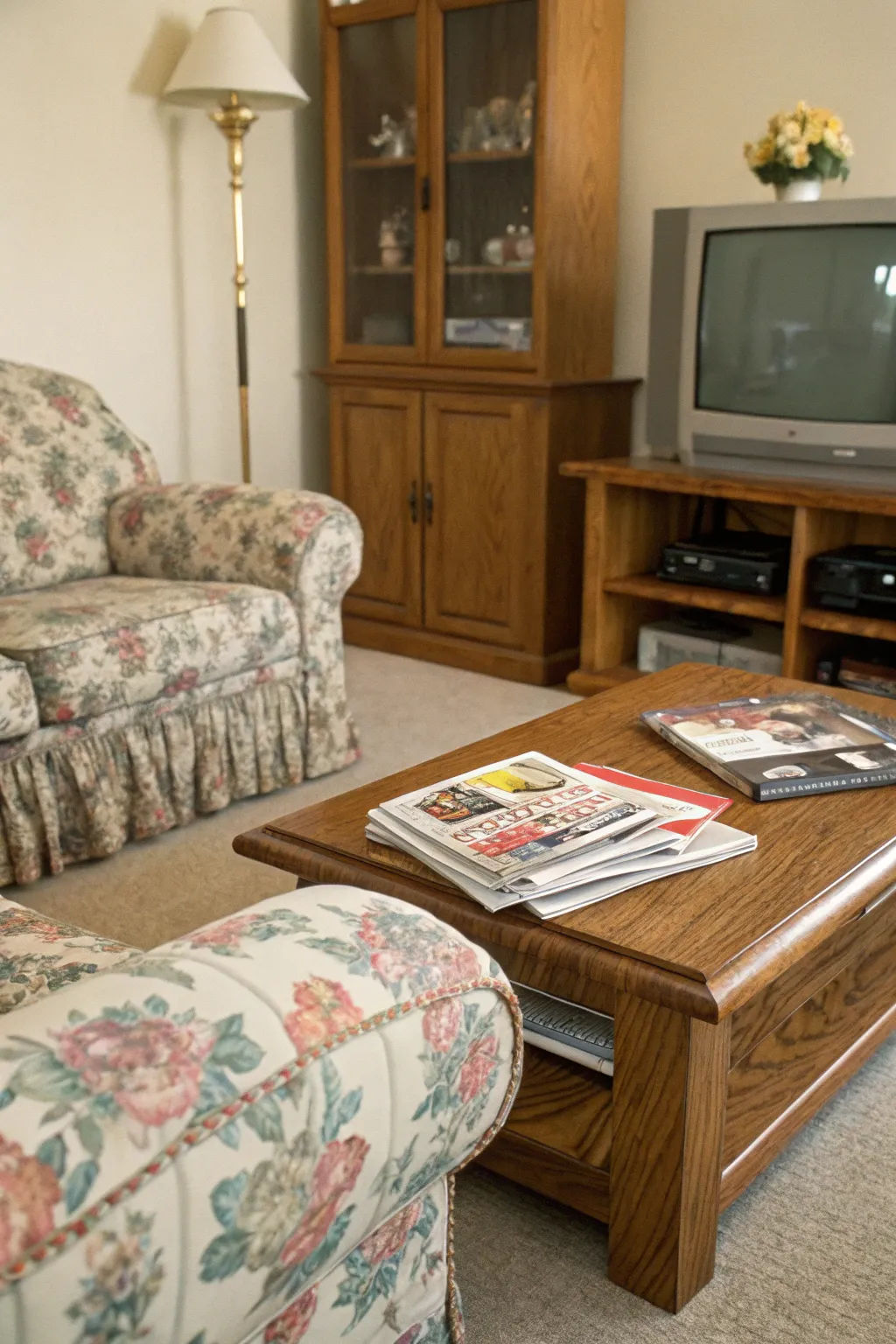 A cozy 1990s living room with a stack of dog-eared magazines on a coffee table.