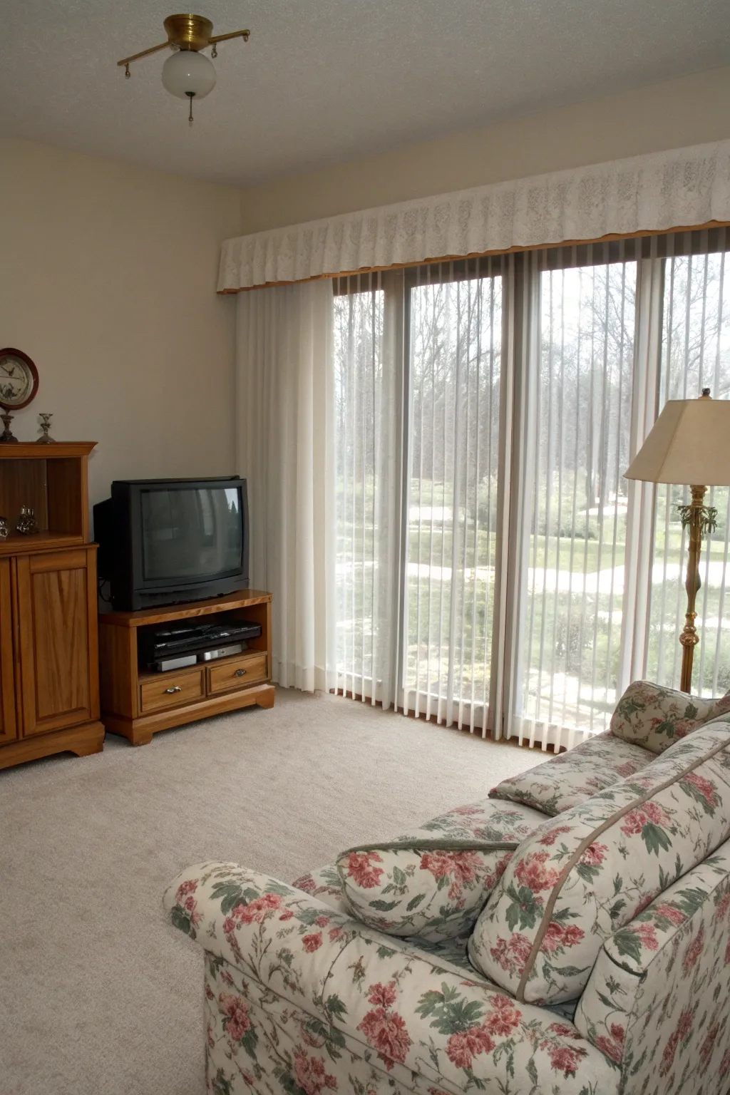 Vertical blinds paired with sheer curtains in a cozy 1990s living room.