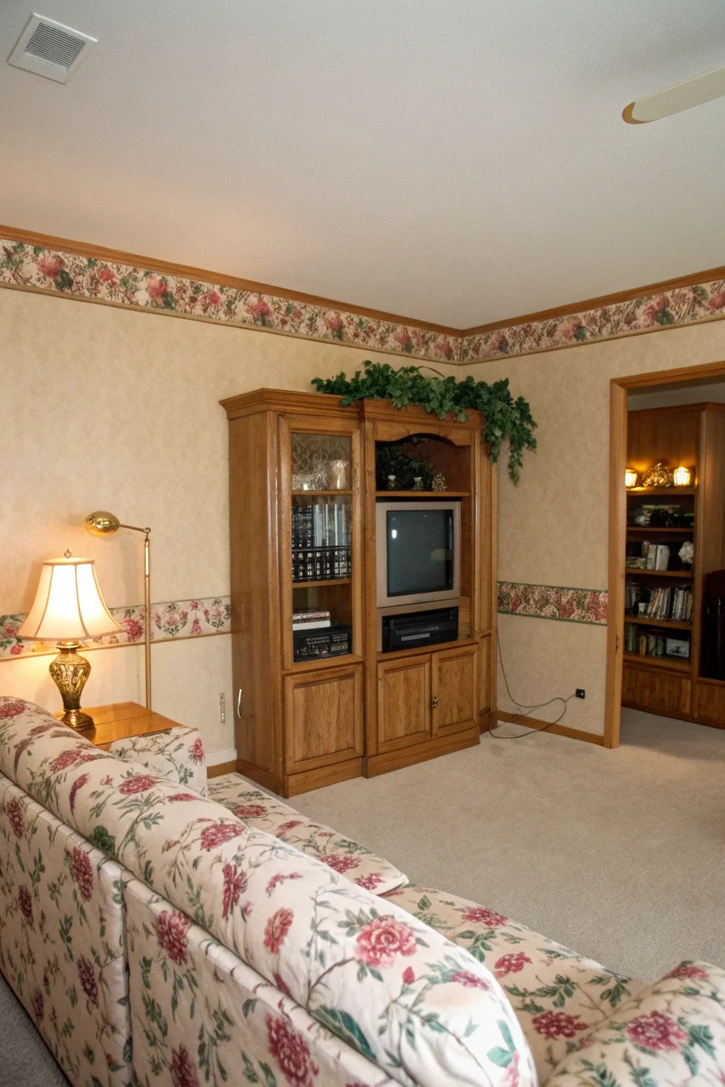 Warm beige walls with a floral wallpaper border in a cozy 1990s living room.