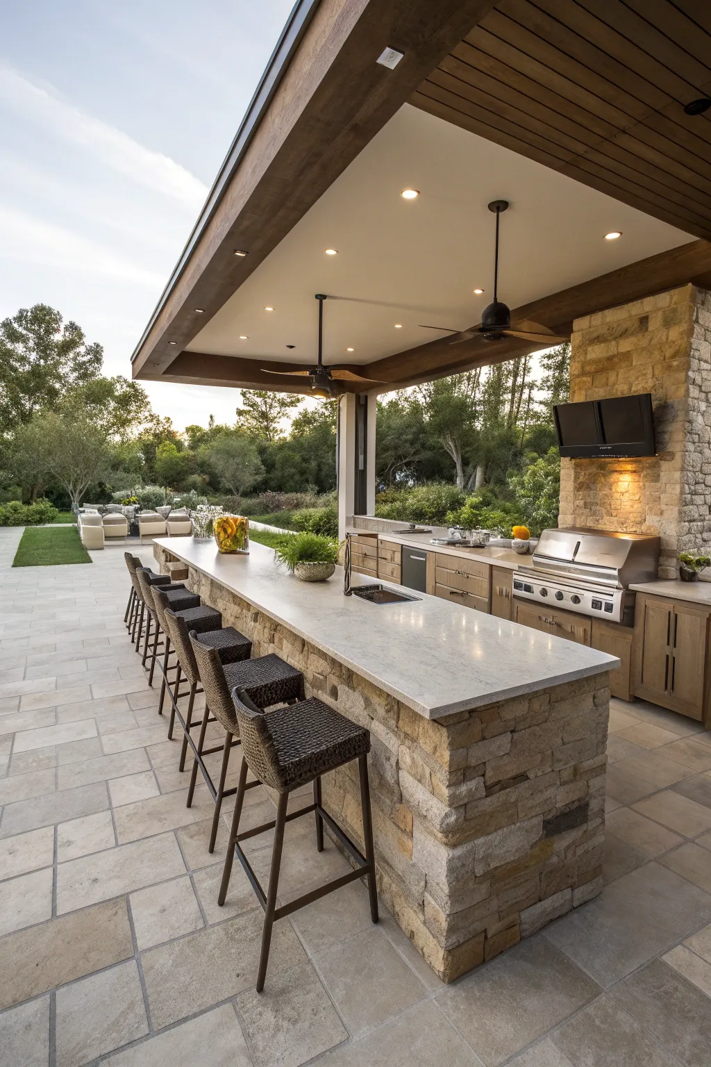 A modern outdoor kitchen island with a granite top and four sleek bar stools.
