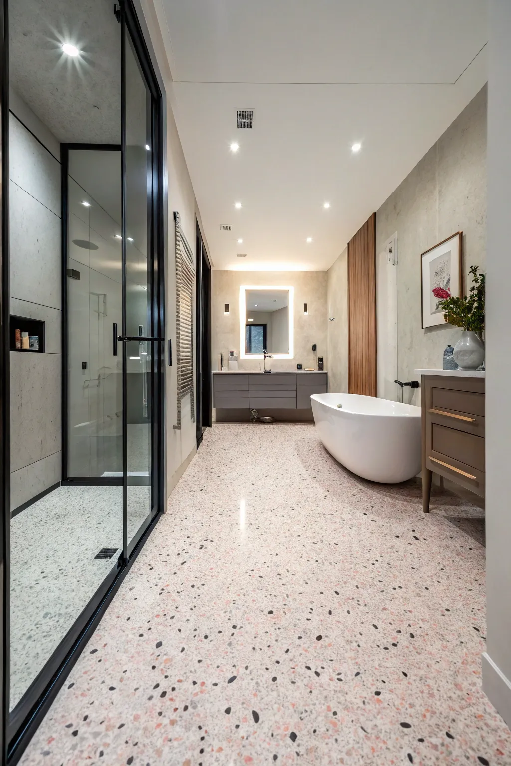 A modern bathroom featuring speckled pink and grey terrazzo flooring and matching pink walls.