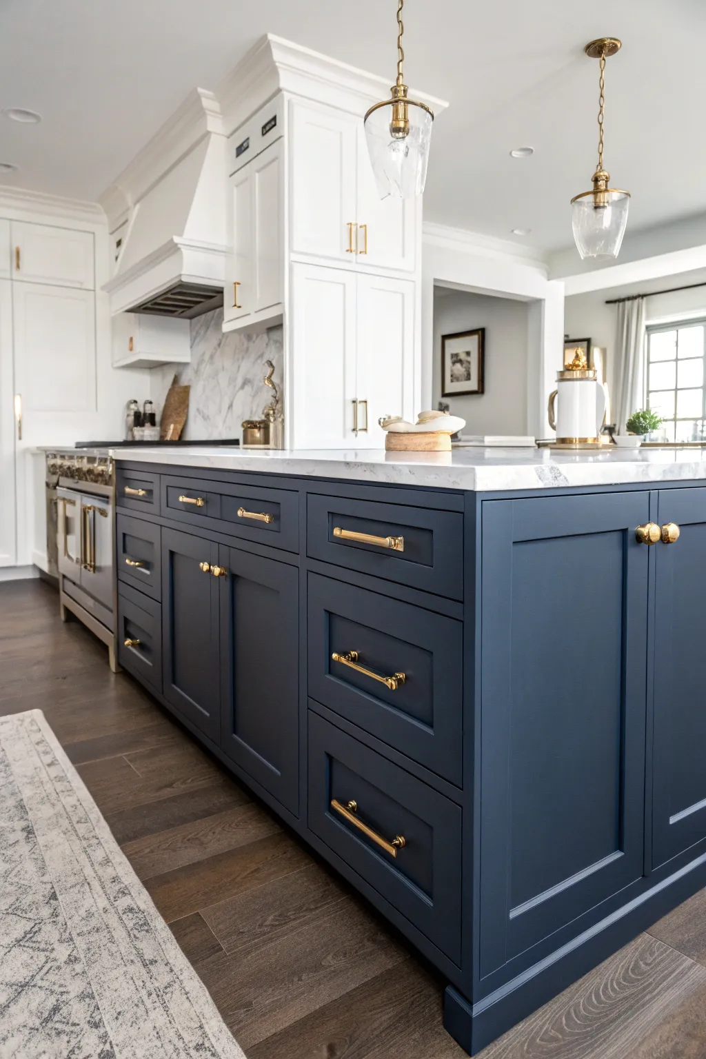 Dark navy blue kitchen cabinets with elegant antique brass handles and marble countertops.