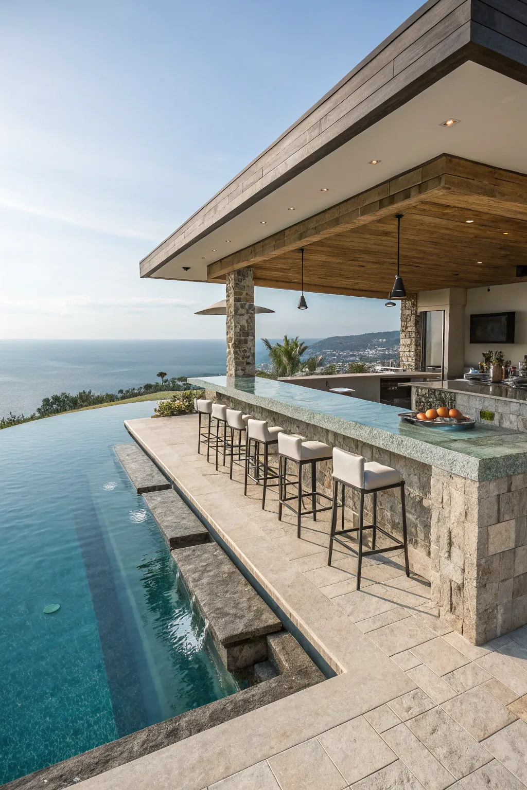 A luxury sunken bar at the edge of a swimming pool with submerged concrete stools.