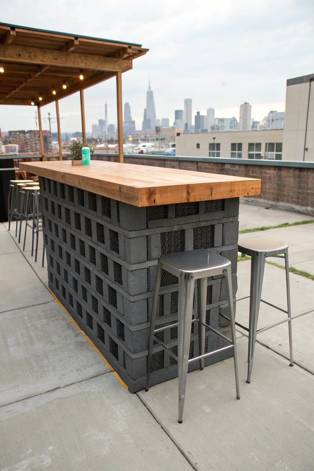 DIY outdoor bar made of painted cinder blocks with a thick butcher block wood top.