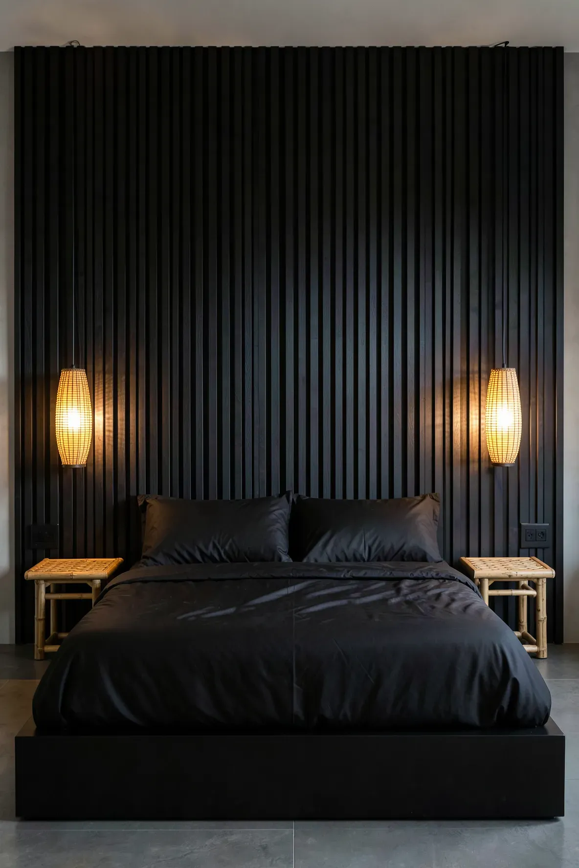 A black slat wall headboard with glowing bamboo pendant lights in a modern bedroom.