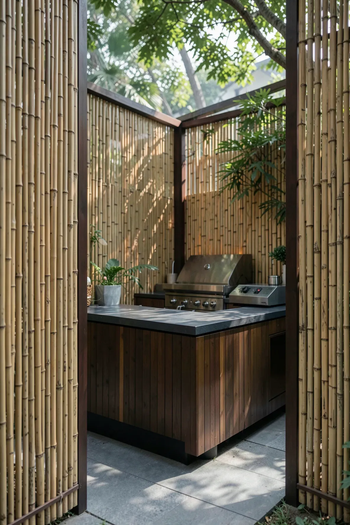 Natural bamboo privacy screens surrounding a modern outdoor kitchen area for a secluded feel.