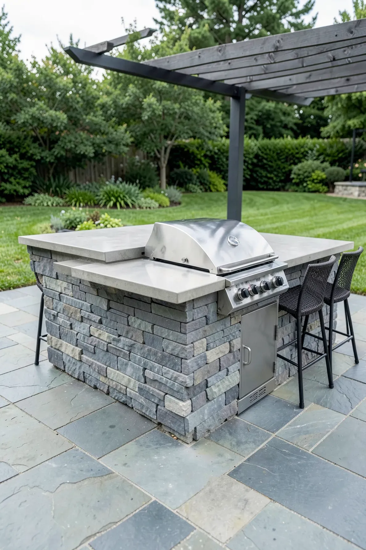 A permanent stone island bar with an integrated stainless steel grill on a luxury patio.
