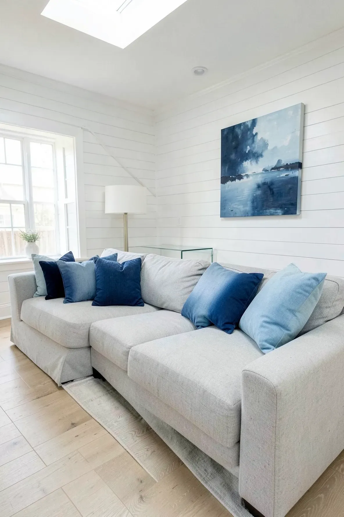 A gray sofa featuring a row of pillows transitioning from dark navy to light sky blue.