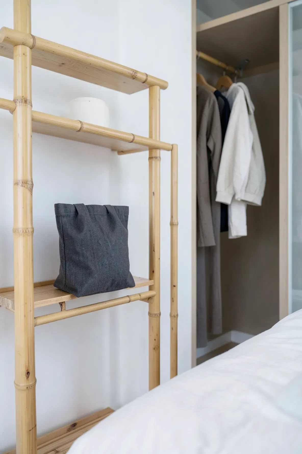 Linen bamboo charcoal bags placed on a bamboo shelf for natural air purification in a bedroom.