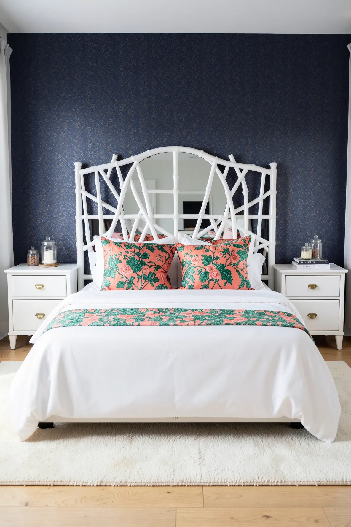 A high gloss white faux bamboo headboard against a navy blue patterned wallpaper in a bright, modern bedroom.