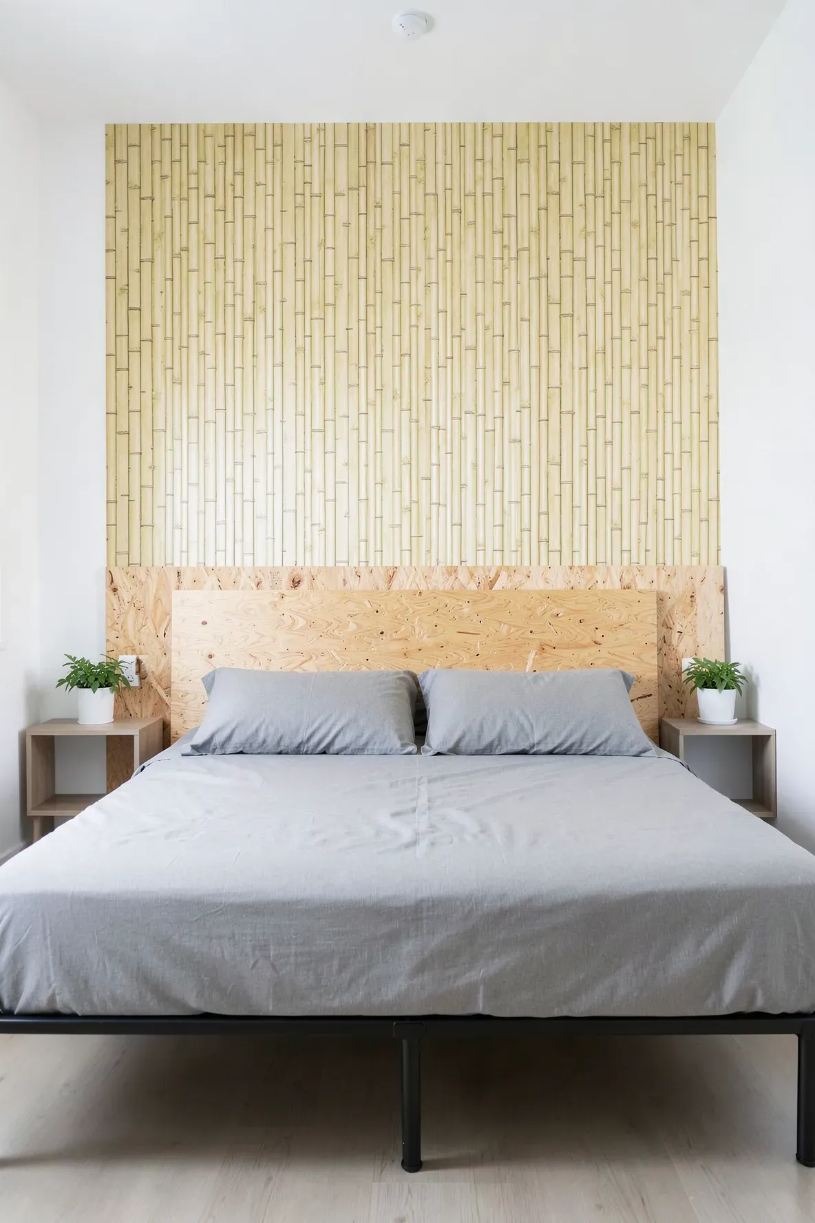 A modern bedroom featuring a headboard created with bamboo-textured wallpaper on a wall panel.