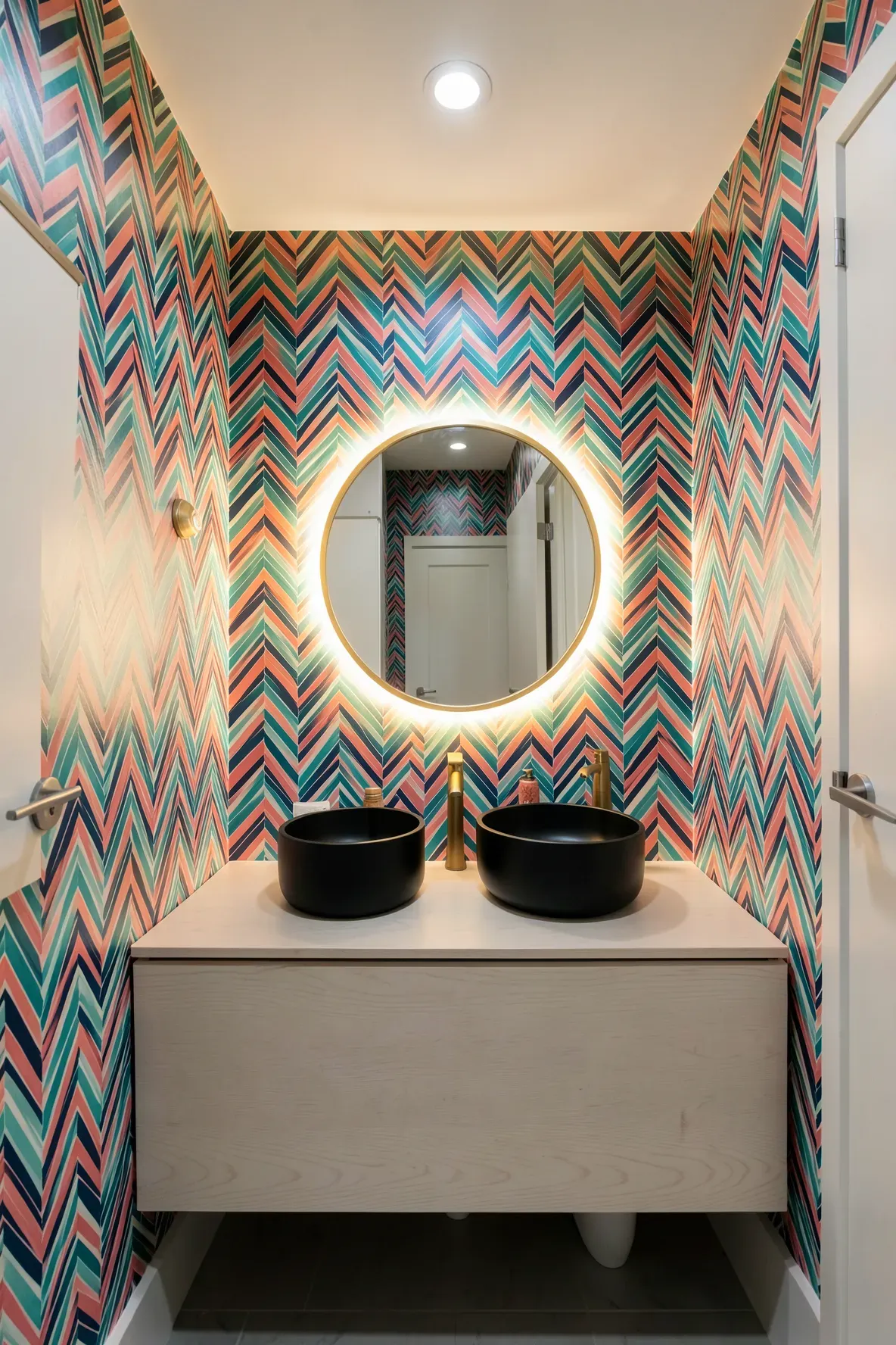 A modern bathroom with a colorful herringbone wallpaper accent wall and a floating vanity.
