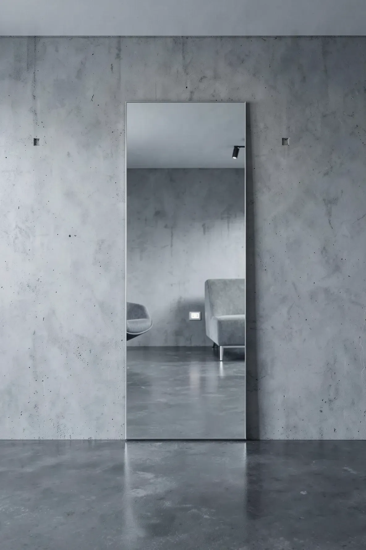 A sleek frameless full-length mirror mounted on a minimalist gray wall.