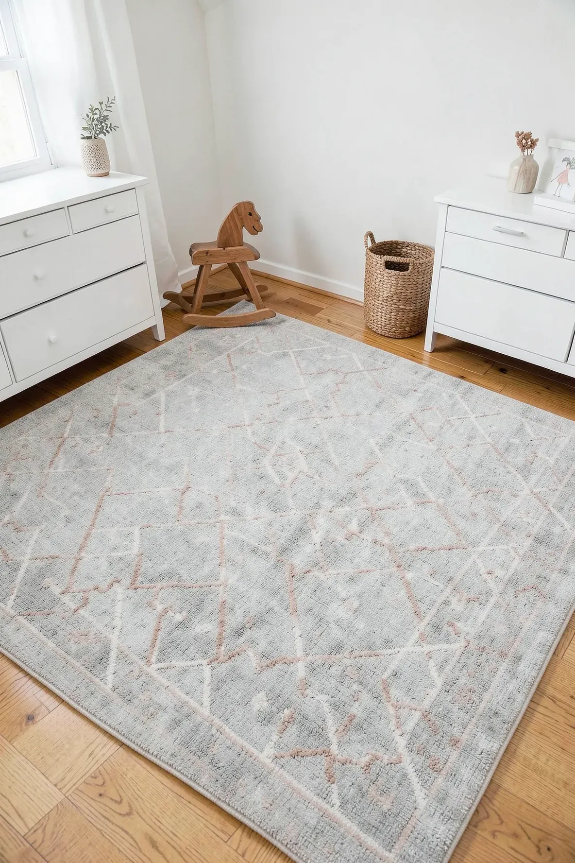 A clean, patterned washable rug on a nursery floor surrounded by modern white and wood furniture.