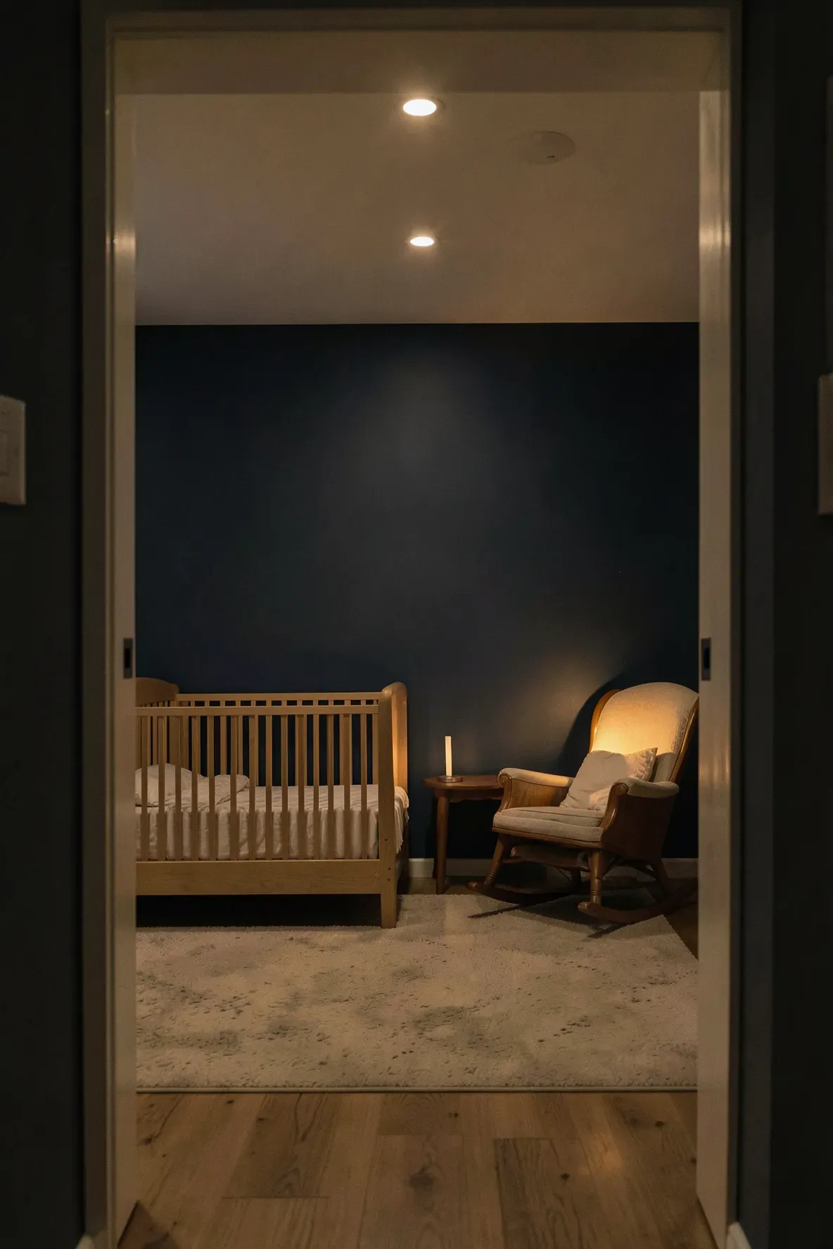 A dimly lit nursery at night with warm, low-intensity amber lighting and a cozy atmosphere.
