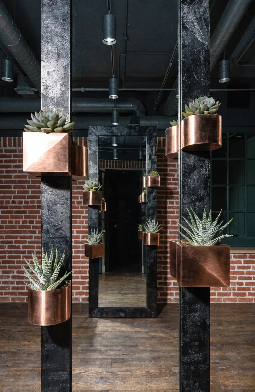 A black metal framed mirror with small magnetic succulent planters attached to the frame.