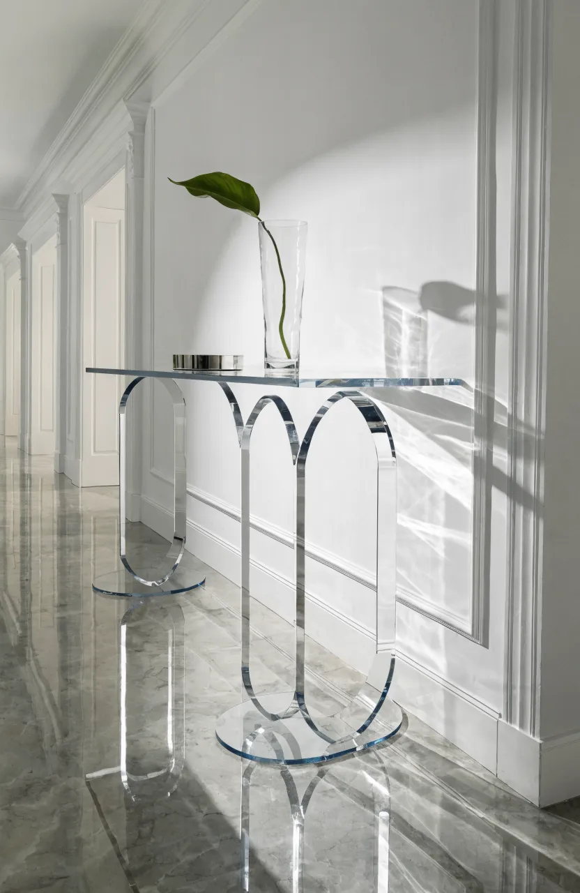 A clear acrylic console table against a white wall in a narrow hallway, looking nearly invisible.