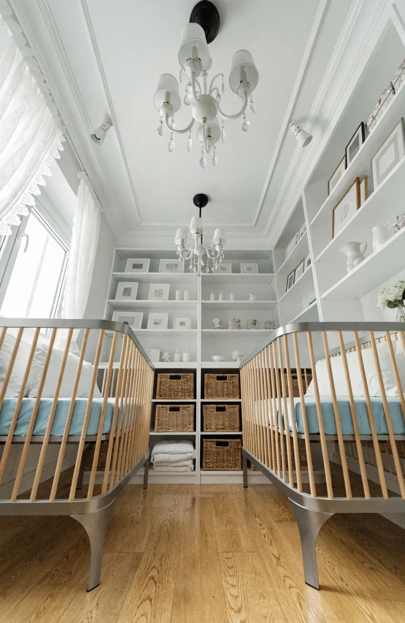 A compact twin nursery with white floor-to-ceiling shelves maximizing storage and floor space.