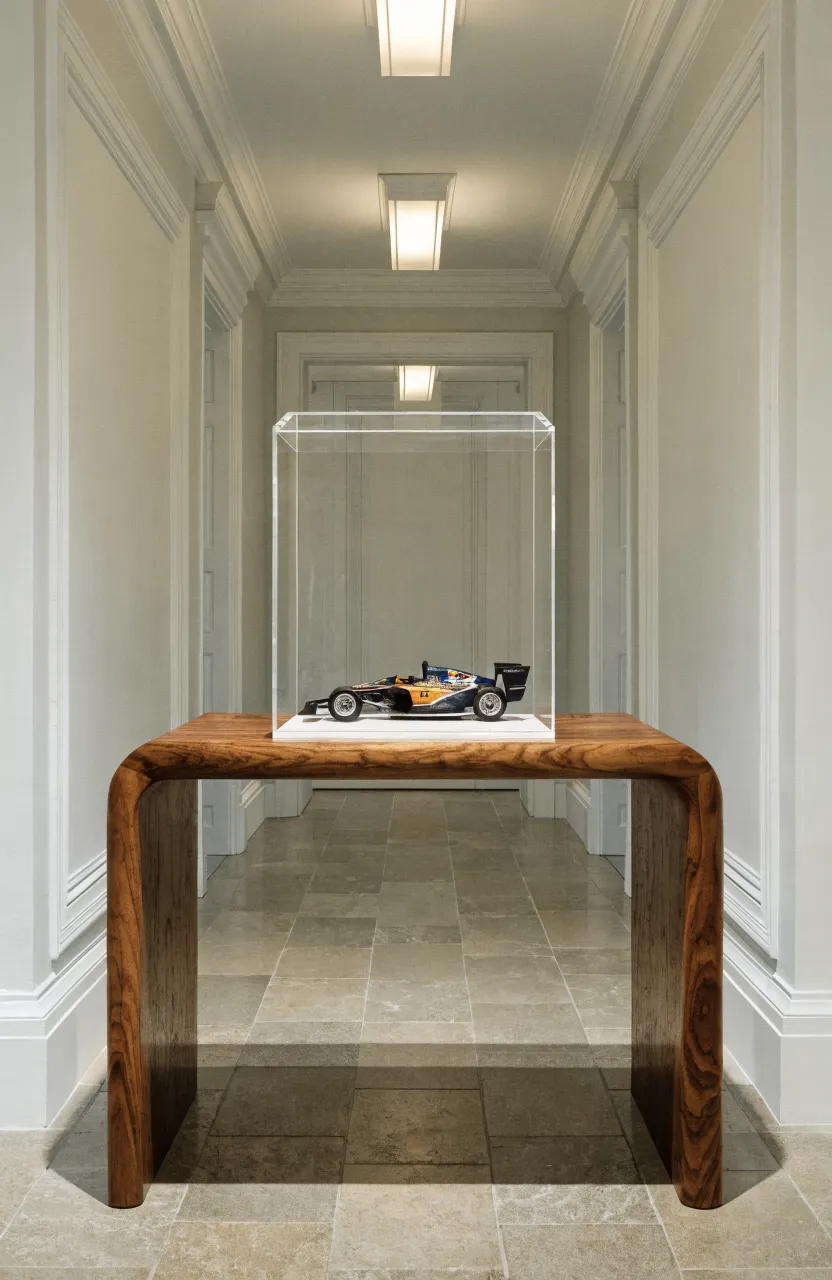 A rare Lego set protected inside a clear acrylic display case on a wooden console table.