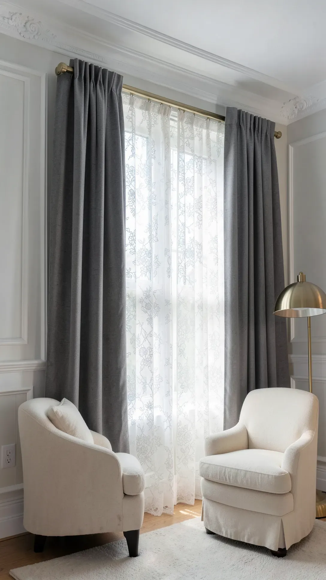 An elegant window setup with a double rod holding sheer lace panels and heavy gray curtains.