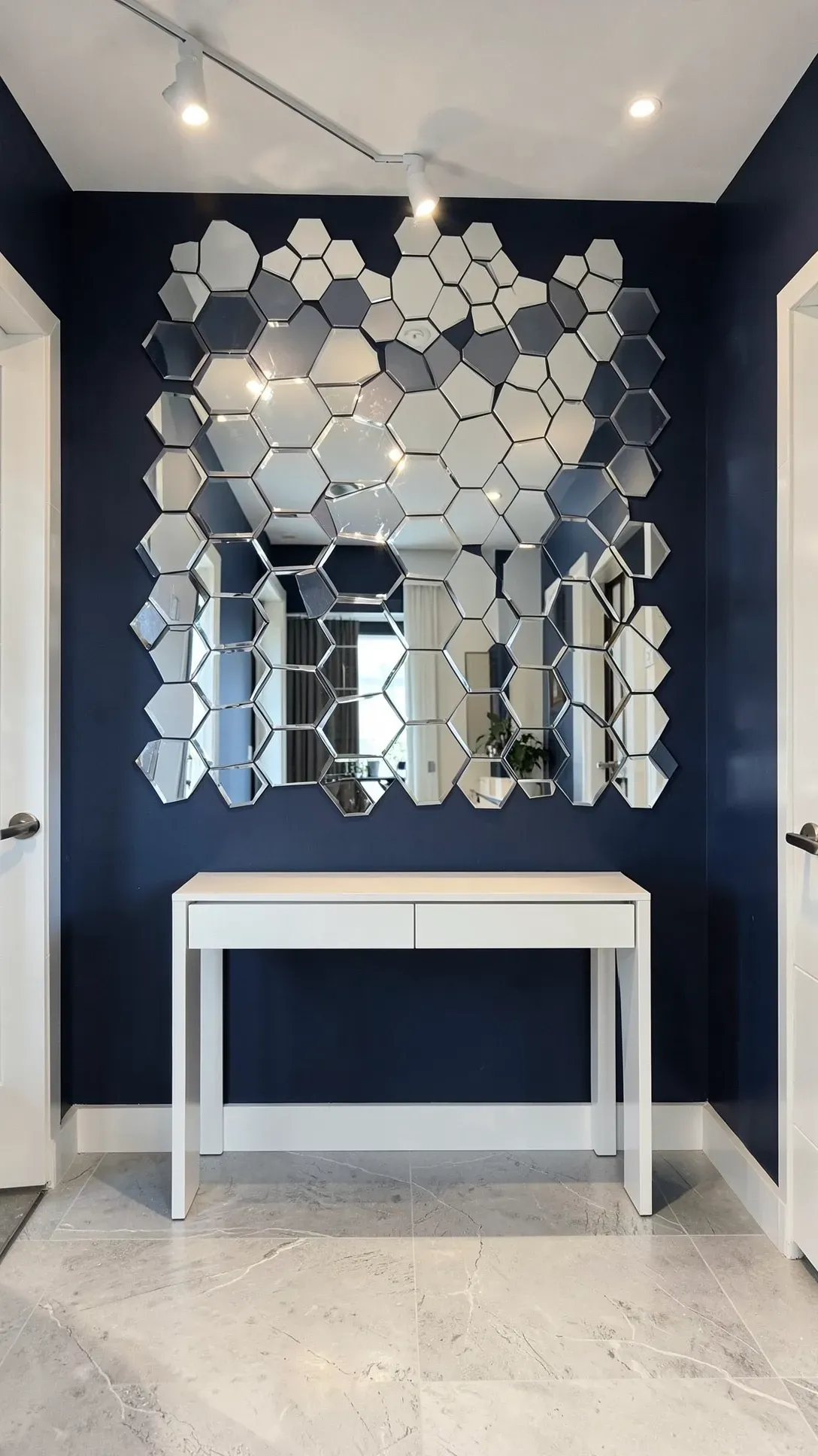 Hexagonal mirror tiles arranged in a honeycomb pattern on a navy blue entryway accent wall.