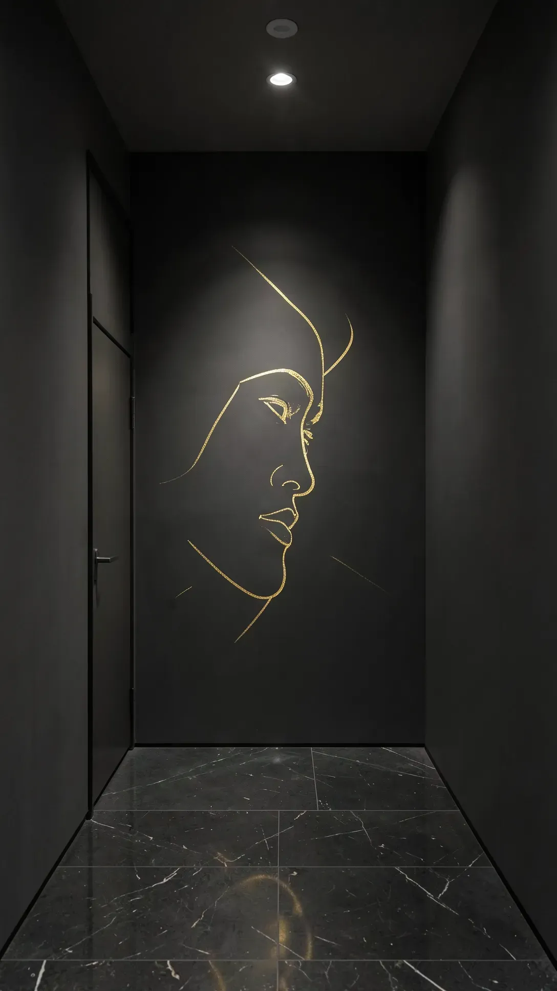 A minimalist gold single-line face mural painted on a dark charcoal hallway wall.