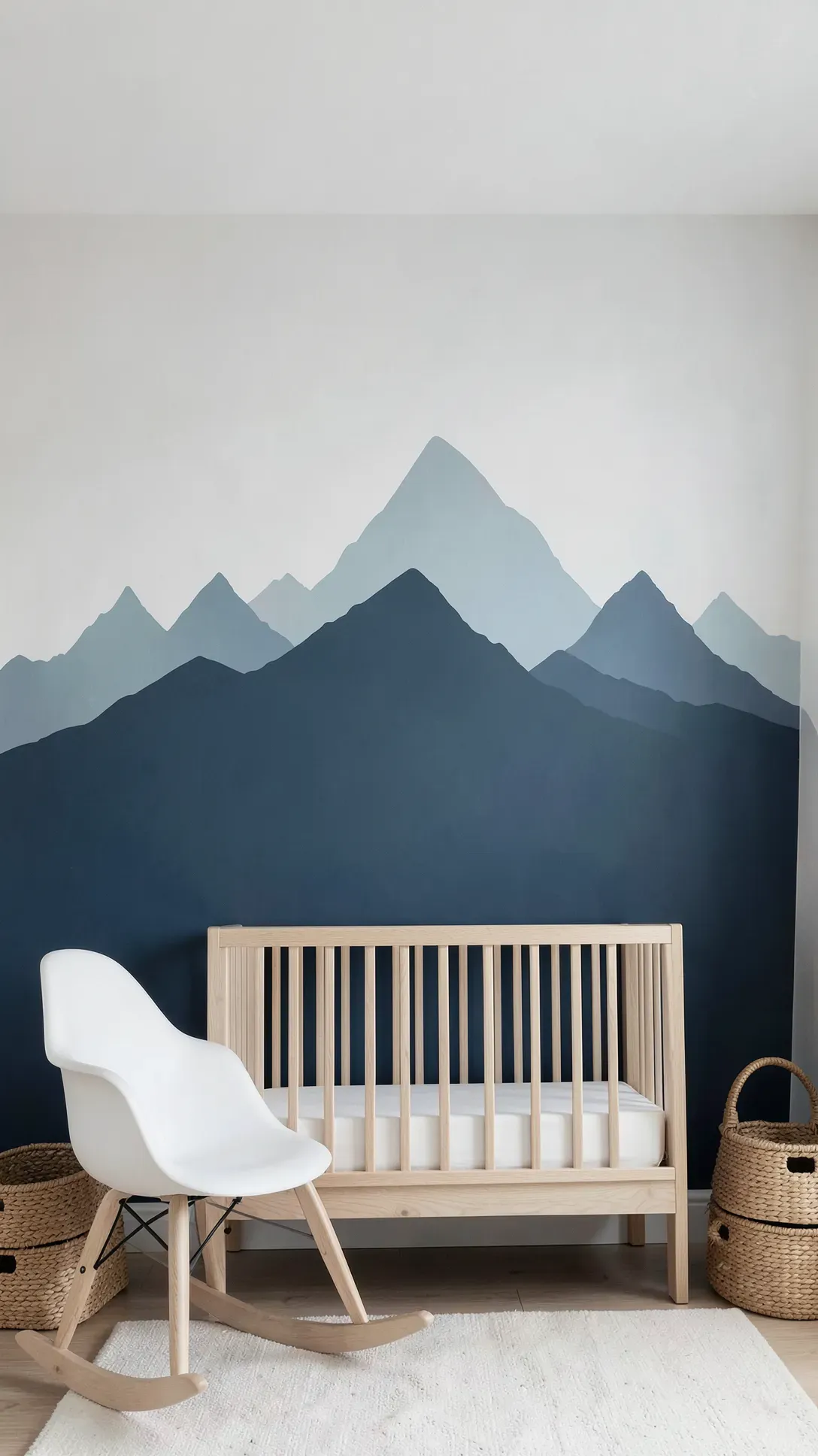 A nursery wall with a blue monochrome mountain range mural in layered silhouette style.