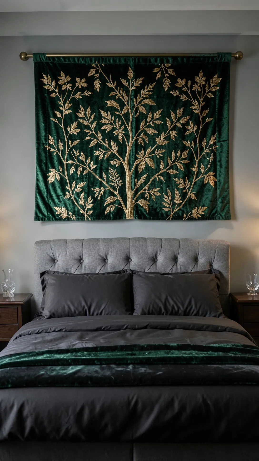 An emerald green velvet botanical tapestry hanging from a brass rod on a bedroom wall.