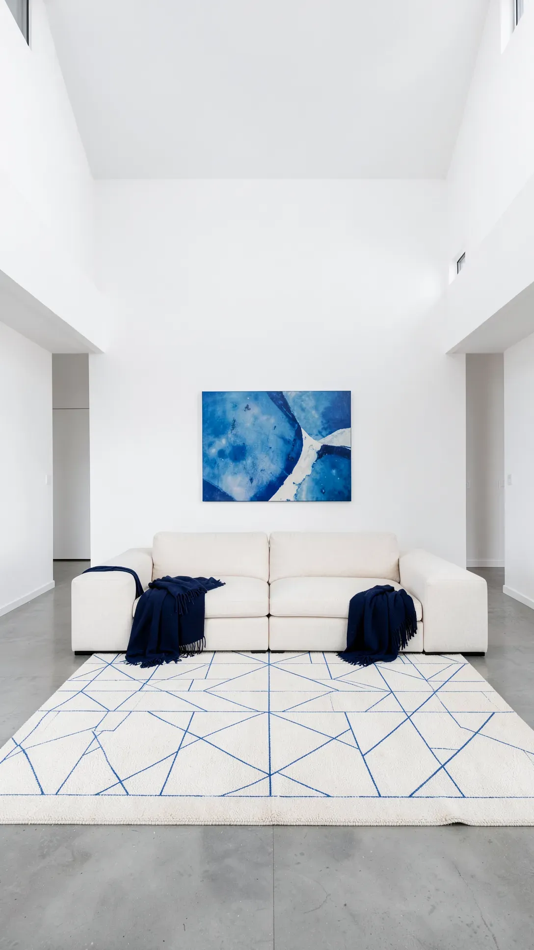 A minimalist cream rug with thin blue geometric lines in a modern, open-concept living room.