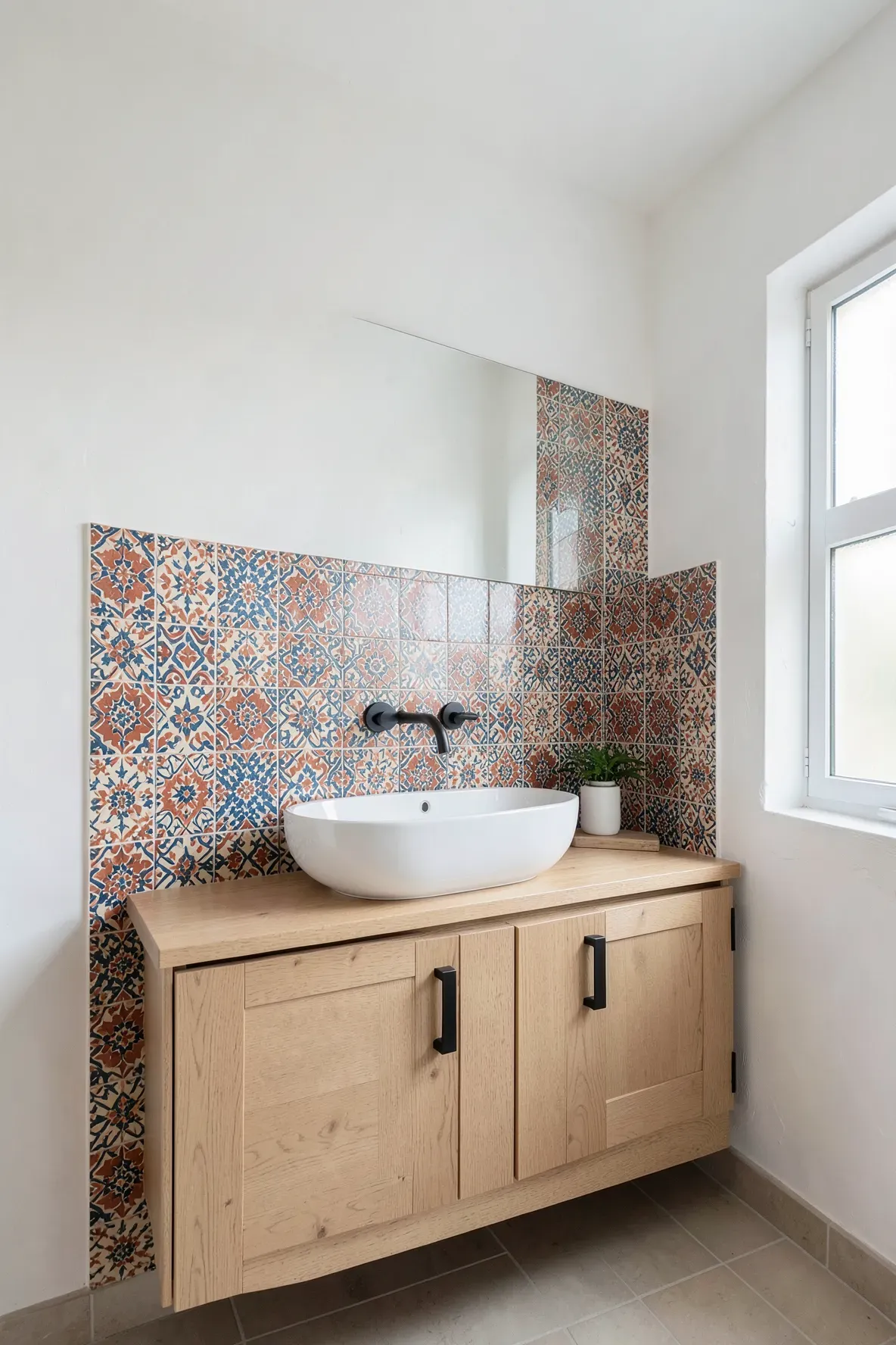 A bright boho bathroom featuring a colorful Moroccan pattern tile backsplash behind a white vessel sink.