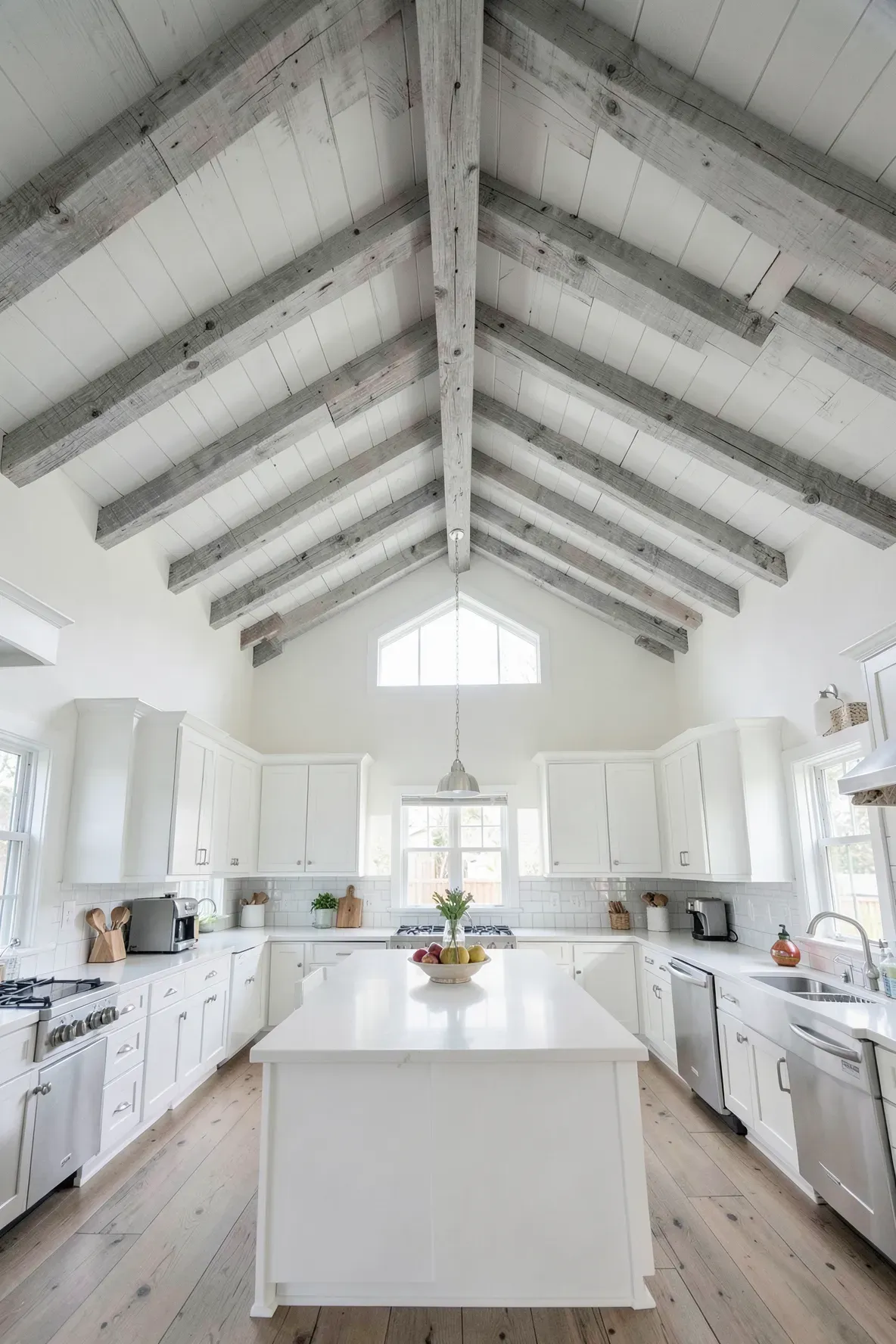 Exposed ceiling beams with a driftwood wash finish in a high-ceilinged kitchen.