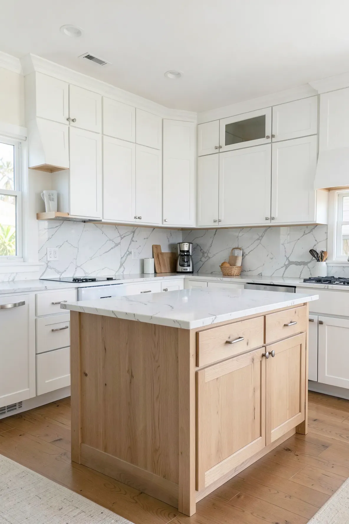 Modern kitchen featuring white shaker cabinets and warm light wood island accents.