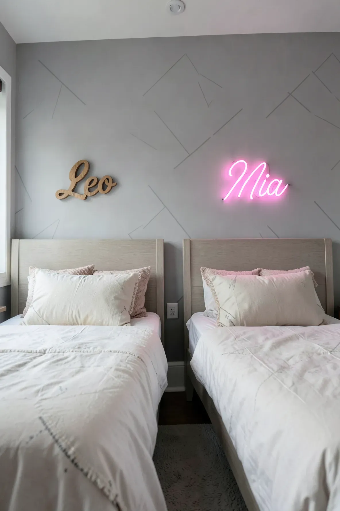 Custom name signs mounted on the wall above two separate beds in a shared brother and sister room.