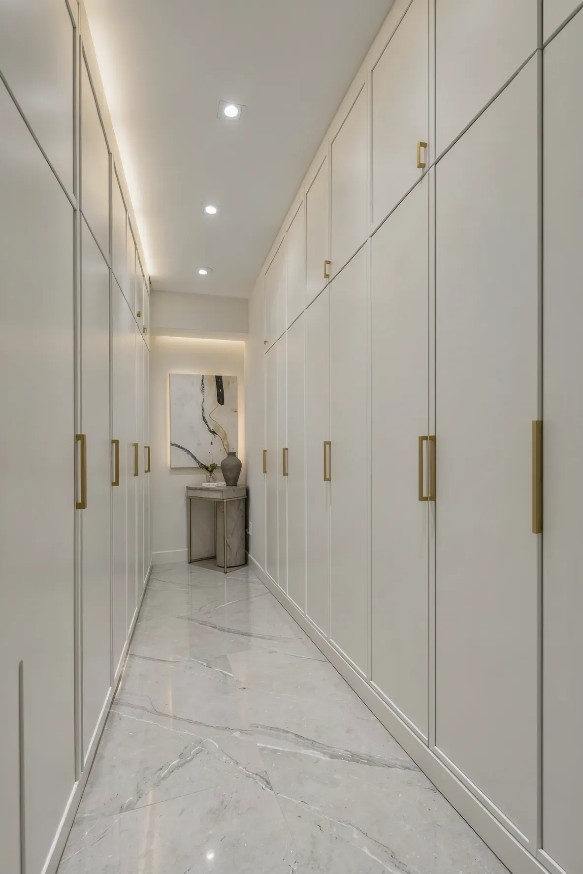 Sleek floor-to-ceiling white cabinets lining a hallway wall for a clean, organized look.