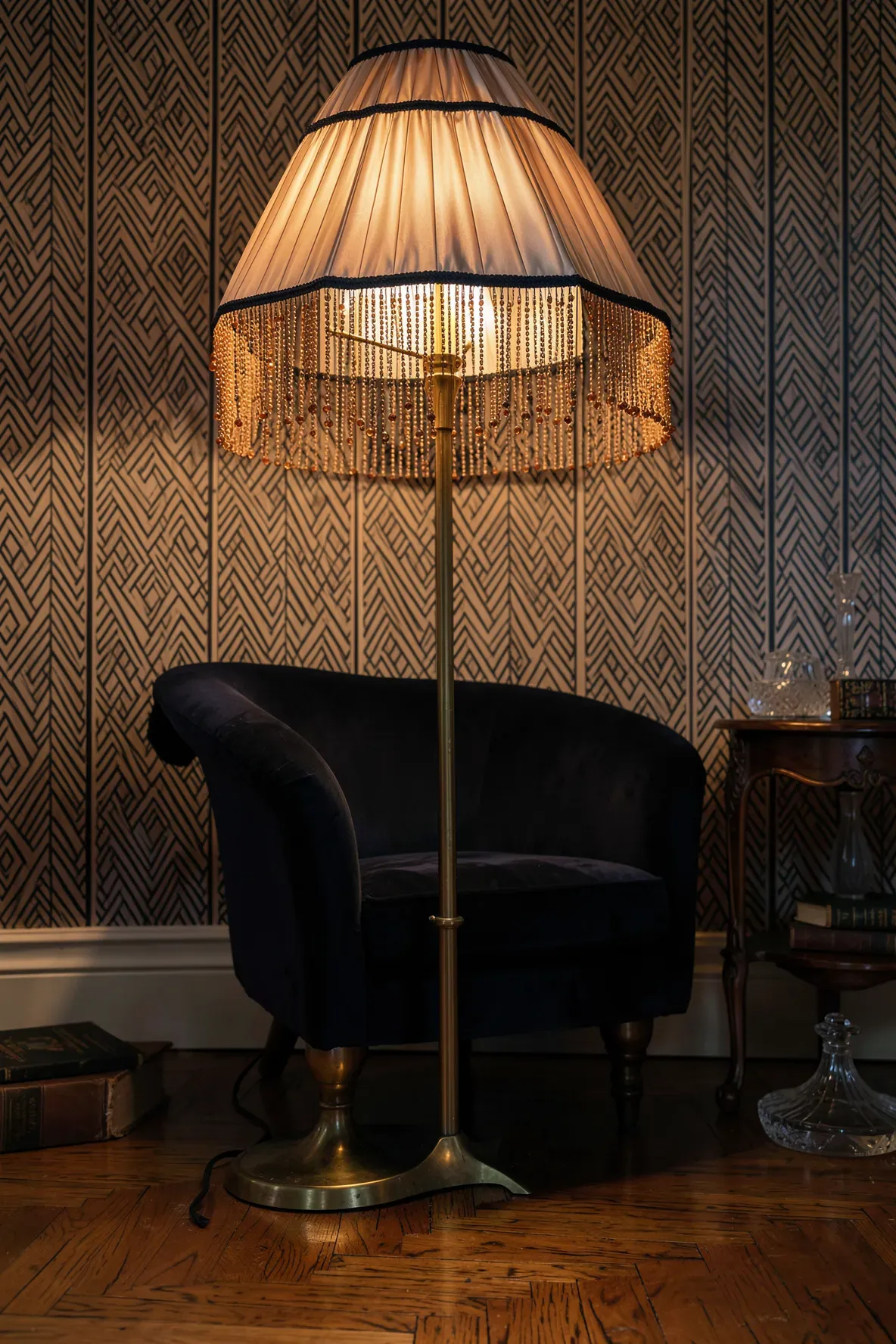 A vintage floor lamp with a pleated silk shade and long beaded fringe in an Art Deco room.
